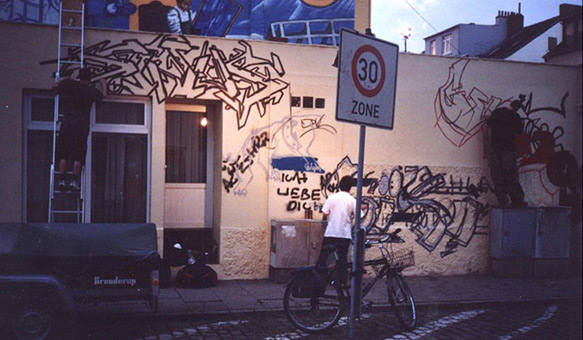 Kunst-und Kulturhappening in der Bremer Neustadt, Buntentosteinweg, Juni 2003. Neben vielen weiteren Künstlern, die von Freitag bis Samstag Ihre Fähigkeiten darboten, konnten 4 Graffitimaler einen liveakt bieten. Sinus, Chesko und Siko Ortner fertigten eine gemeinsame Wandgestaltung an. In den Abendstunden wurde mittels Kunstlicht weitergemalt. 2 Charakter und Siko-style von Siko Ortner. Sinus, Siko und Chesko bei der Arbeit. fest03